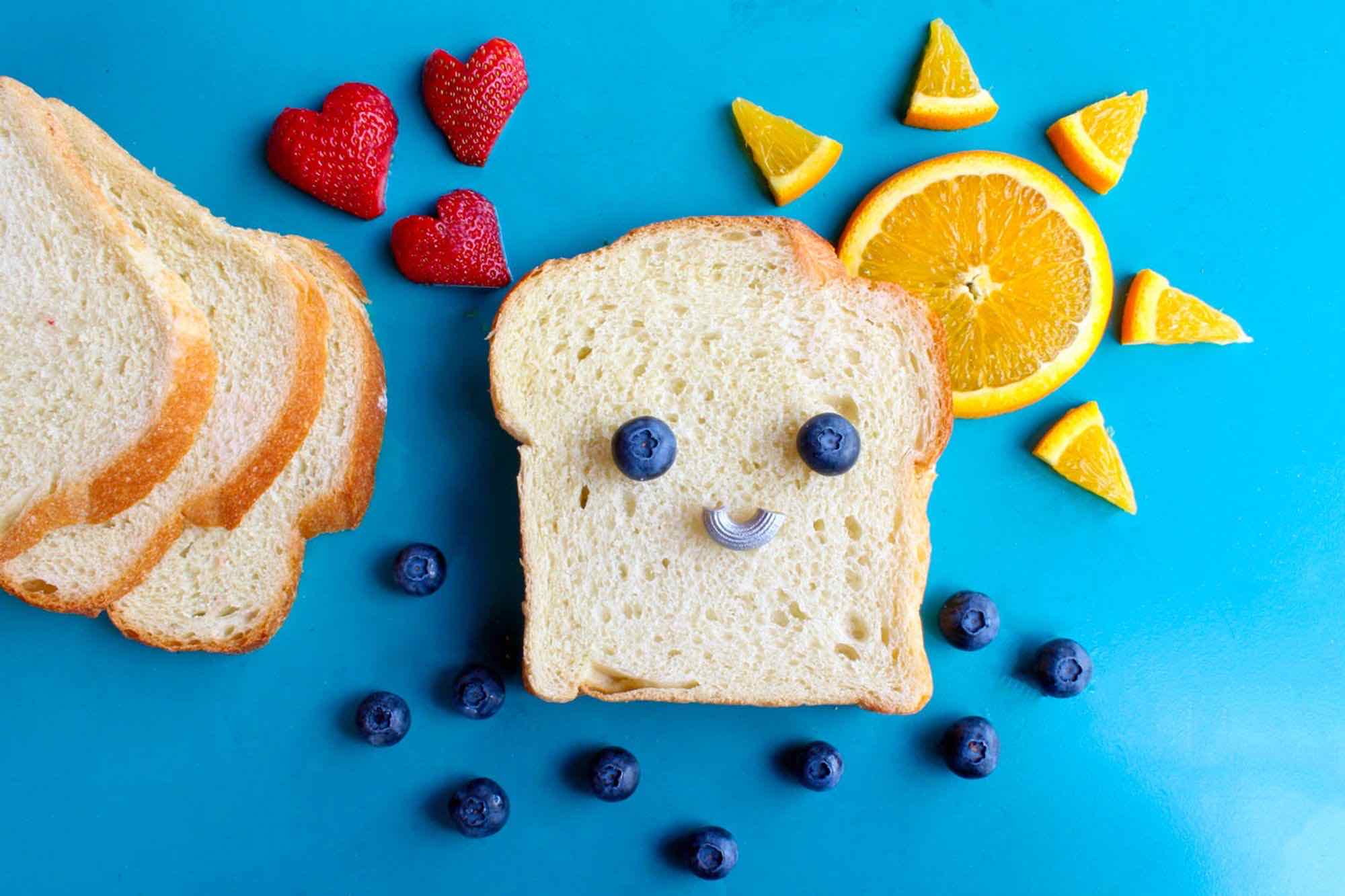 Photo of some food, mostly a smiley face of blueberries atop a slice of white bread